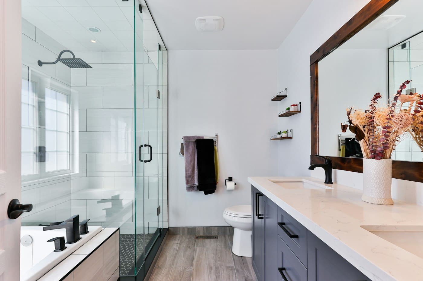 Remodeled bathroom with a tiled walk-in shower and frameless glass enclosure